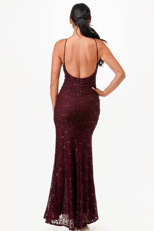 Woman wearing a burgundy lace evening gown on a white background