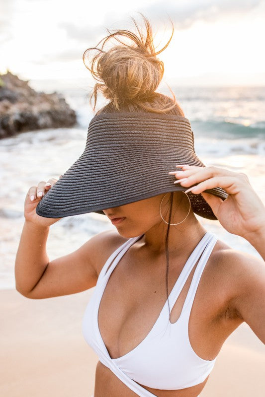 This visor is made of breathable straw with a foldable and portable design, featuring an adjustable velcro closure. It also includes a comfort headband and elastic band for convenient storage. The back has a bow detail and its wide brim provides excellent coverage. One size fits most.