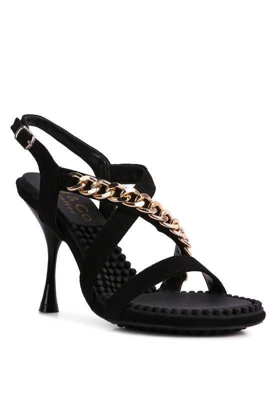 This sandal features a stiletto heel, an open toe, and a microfiber leatherette upper. The lining is made of leatherette, and the outsole is constructed with rubber for added durability. The contemporary design includes a mid heel, groovy insole and outsole, and a pin buckle for easy opening.