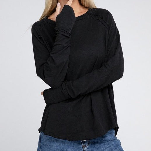 The Cotton Raglan Sleeve Thumbhole Top offers both comfort and style with thumbhole details, raglan sleeves, a hi-low hem, and a back patch for a unique touch. Perfect for both casual and lounging days.