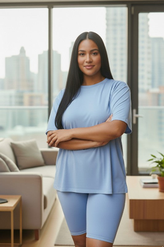 Woman in a blue outfit standing in a modern living room with cityscape view