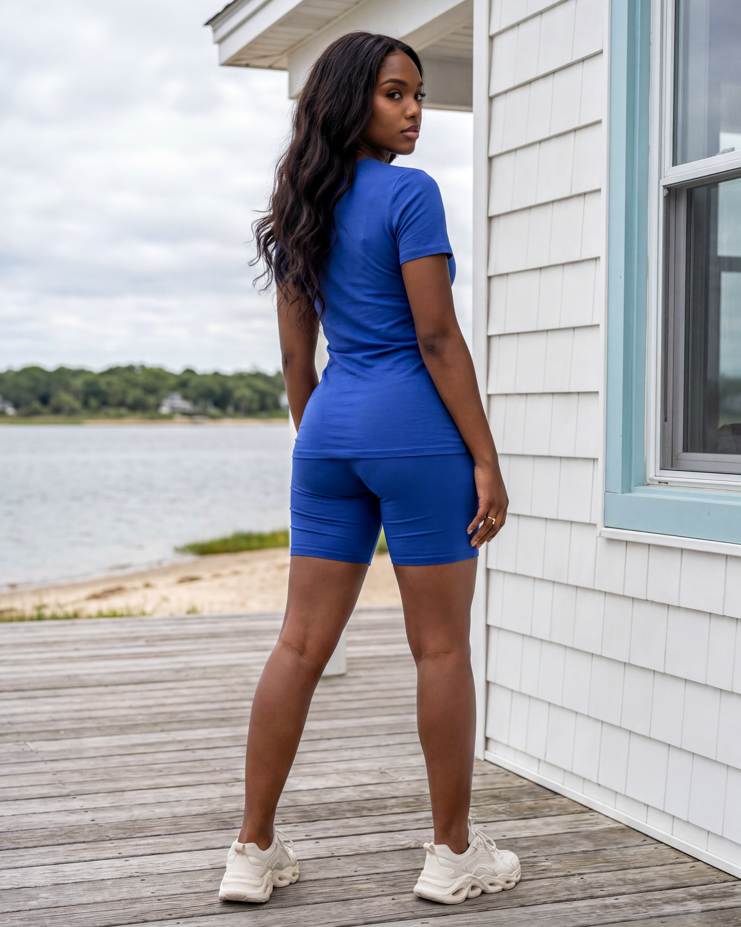 A female model wearing the Kamel Top and Biker Short Set in Royal Blue, showcasing the back view and flattering fit of the matching top and biker shorts. 