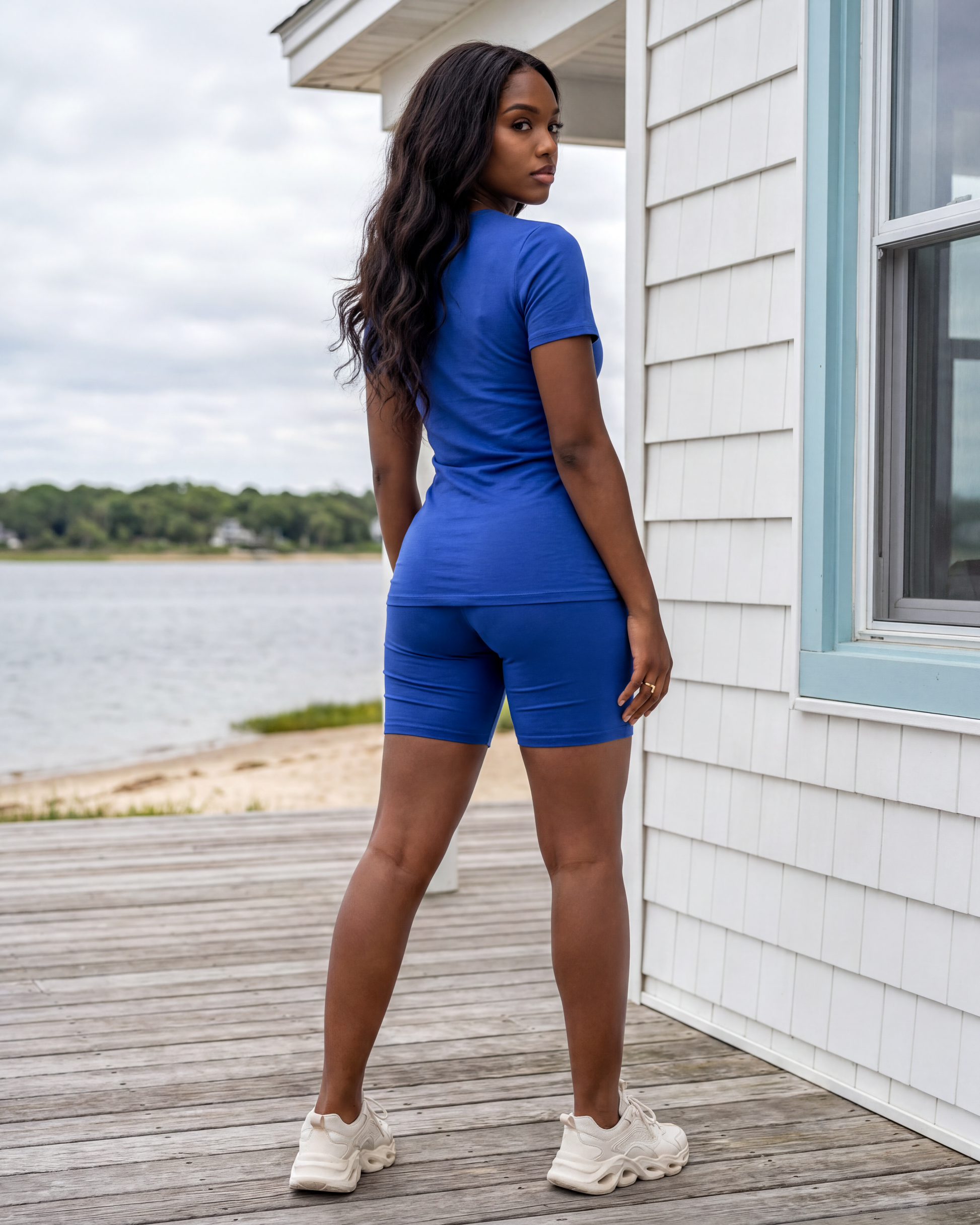 A female model wearing the Kamel Top and Biker Short Set in Royal Blue, showcasing the back view and flattering fit of the matching top and biker shorts. 