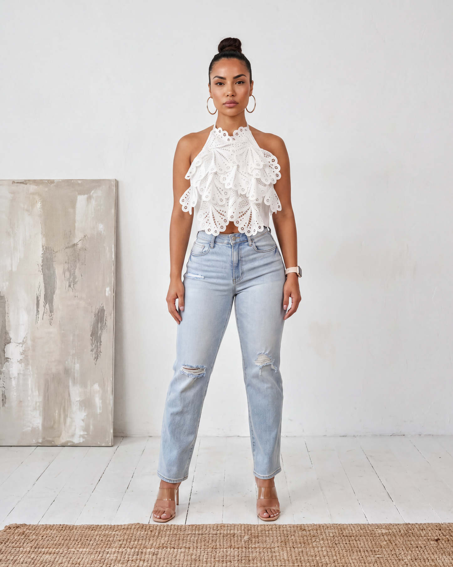 Model wearing the Madison Distressed Straight Denim Jean in light wash blue with a high-rise fit and distressed knee detail, front view.