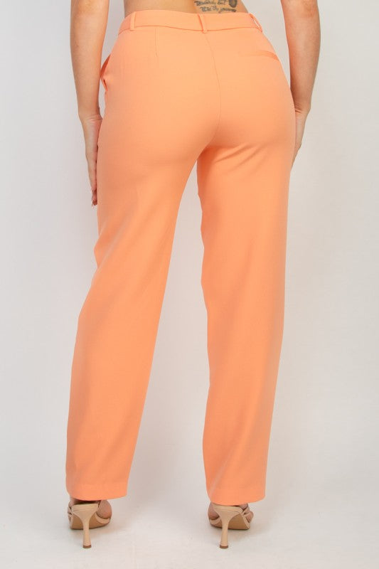 Woman wearing peach-colored pants on a white background