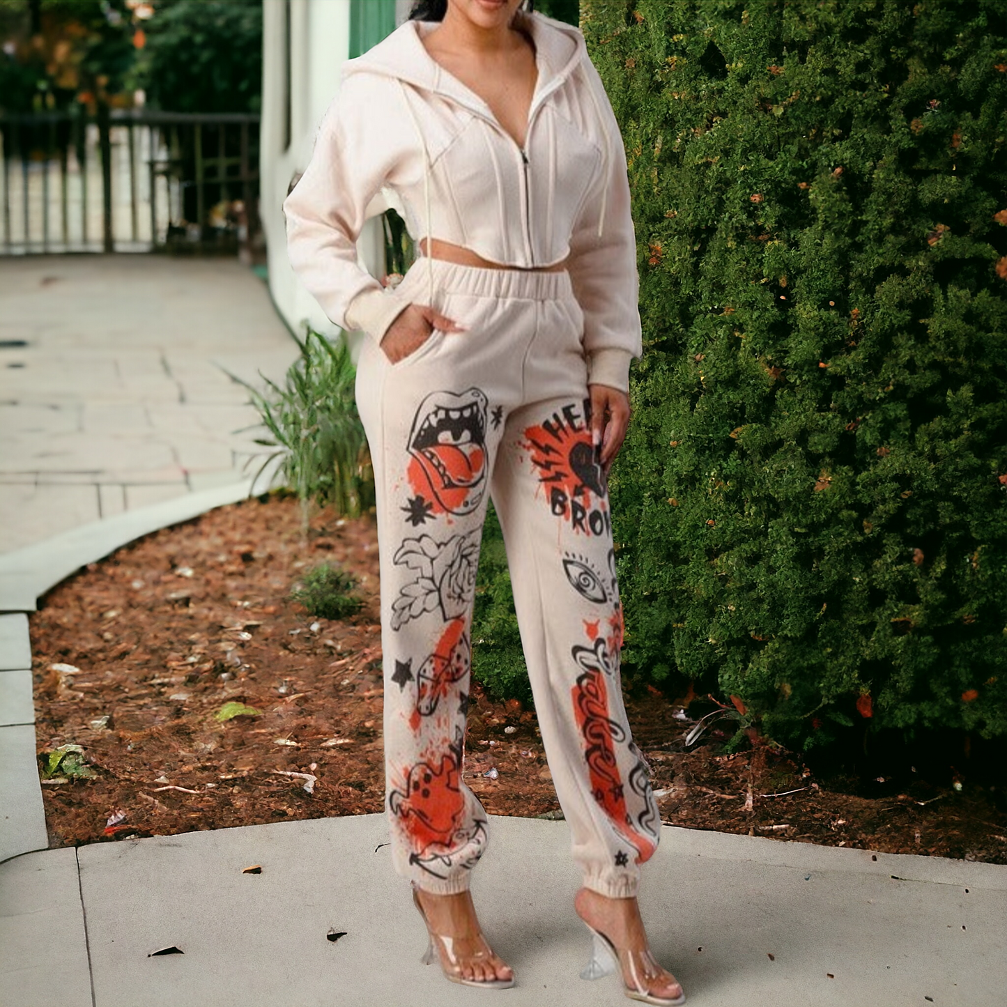 This elegant and modern combination of two garments, in a versatile beige hue, consists of a cozy cropped jacket and matching trousers. Both are adorned with a trendy print.