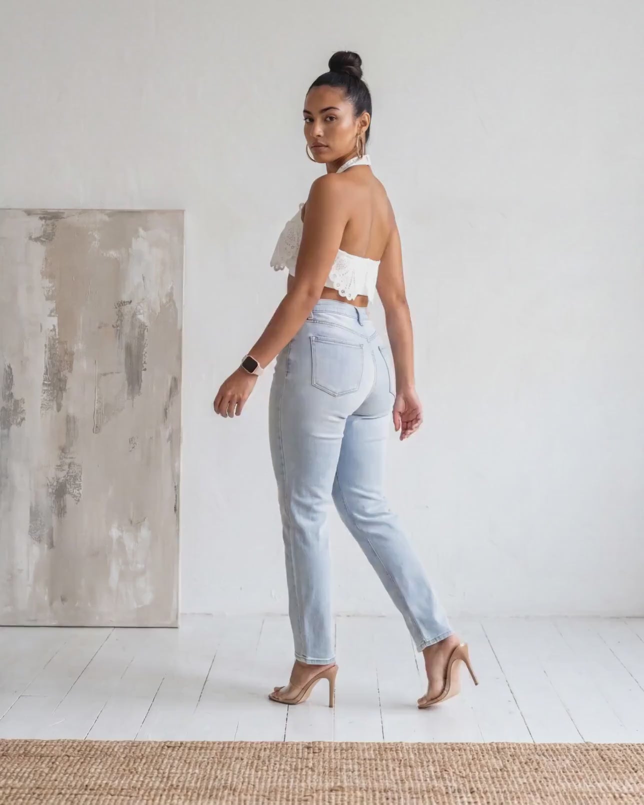 Angled back profile view of the Madison Distressed Straight Denim Jean in a light wash featuring distressed knees and a relaxed straight-leg fit.